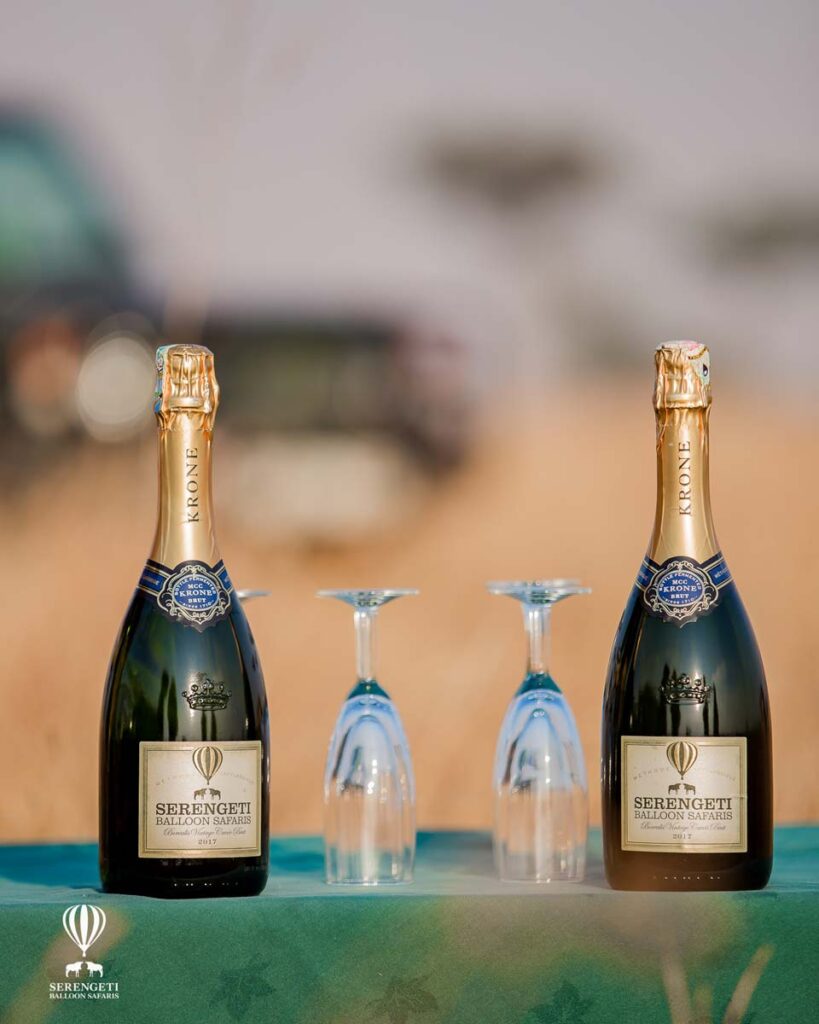 Two bottles of champagne with the flutes in the middle.