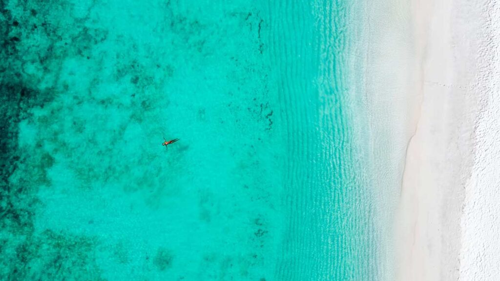 A woman floating on the turqoise-coloured water of the ocean