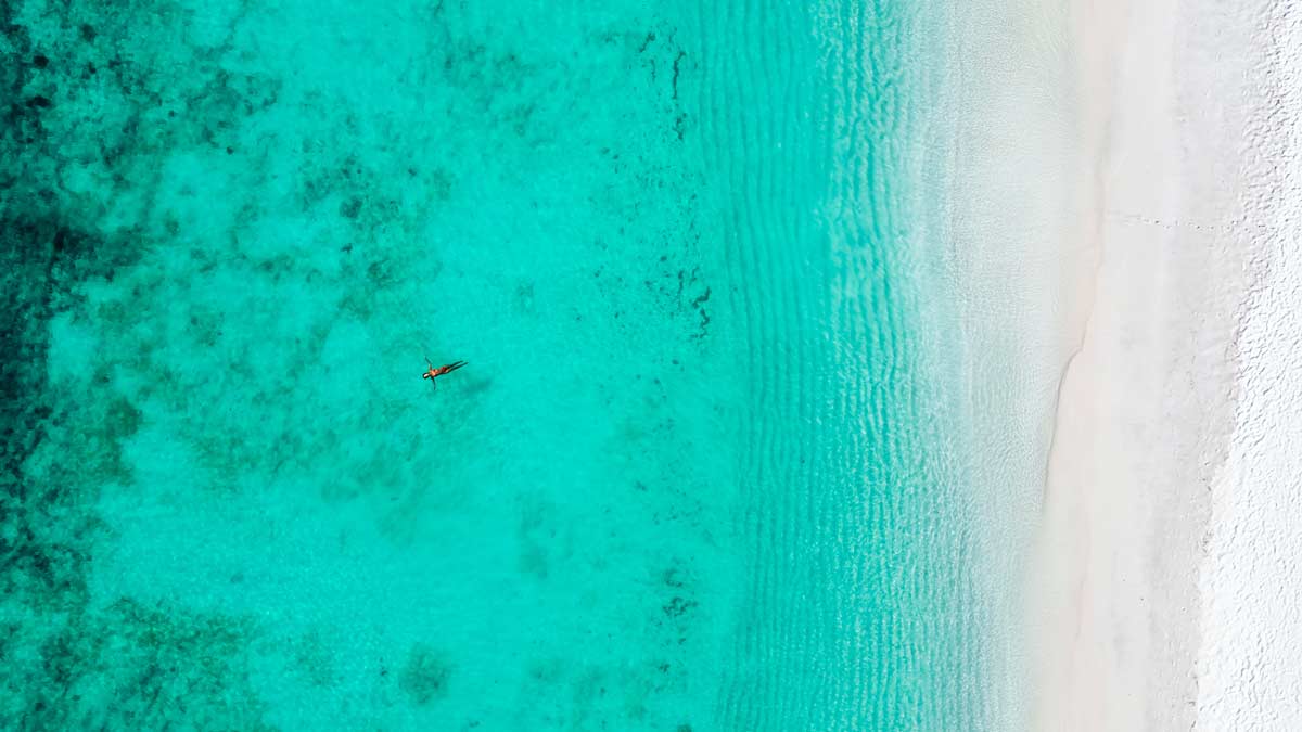 A woman floating on the turqoise-coloured water of the ocean